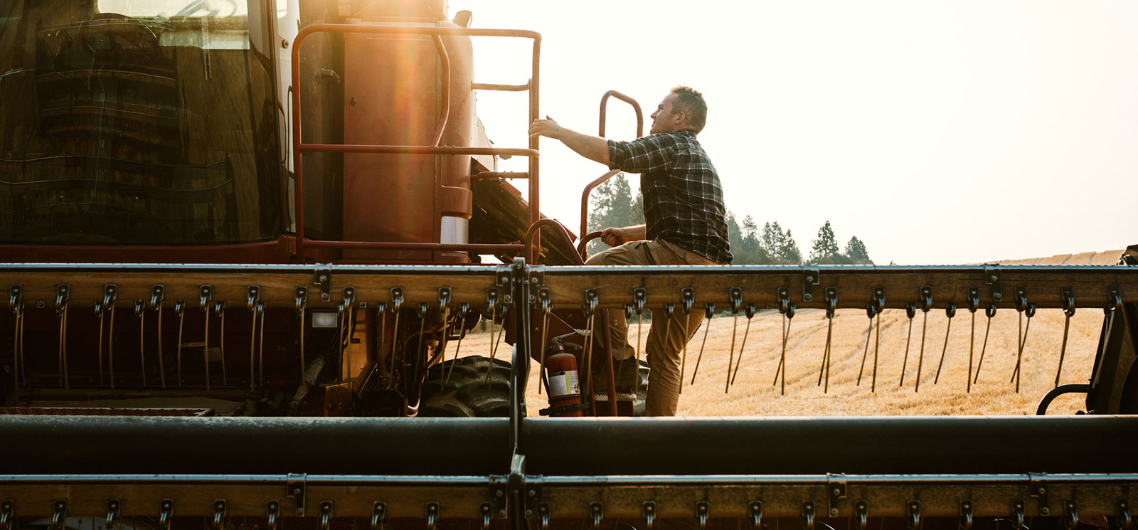 Farmer climbing into combine.