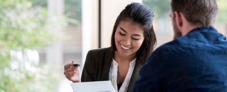 :A man and woman at a table with papers, engaged in a discussion about Commercial Loans.