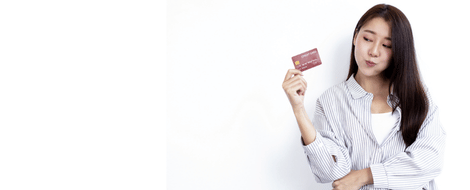 A woman examines her custom debit card design while holding it in her hand, showcasing her personal style.