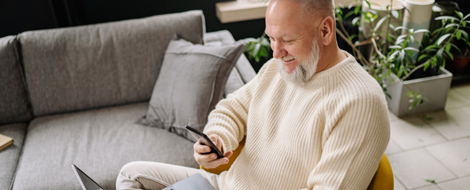 An older man seated with a laptop, focused on learning how to use Zelle for digital payments.